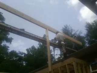 Carpenter setting a ridge beam over a new addition frame — Ice Dam Removal by Roofing Brothers in South San Francisco
