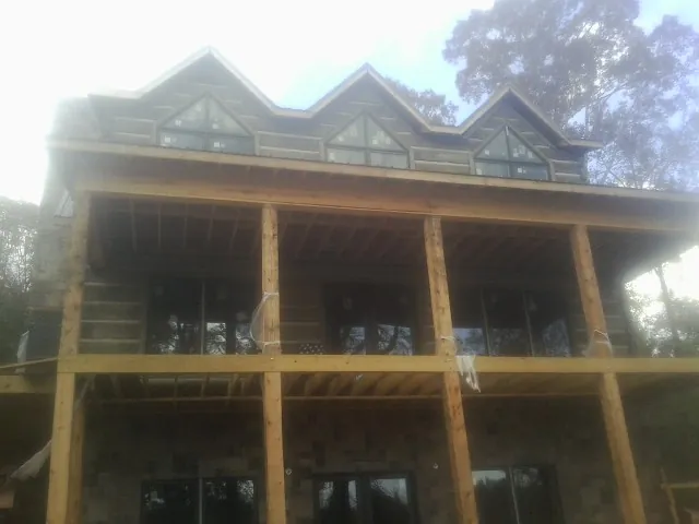 Dormers and porch framing on a large log home under construction — Roof Coating work by our crew in South San Francisco