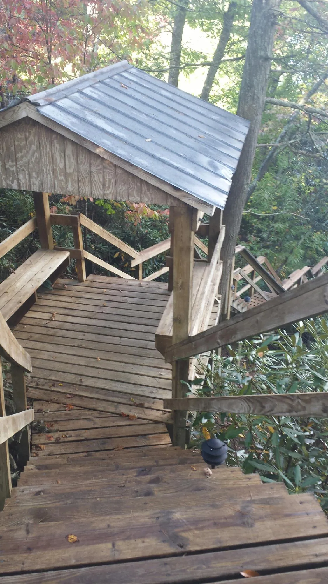 Metal roofed shelter over wooden steps on a wooded walkway — Skylight Repair & Installation work by our crew in South San Francisco